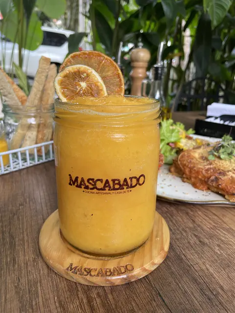 Smoothie de mango en frasco con el nombre de la casa